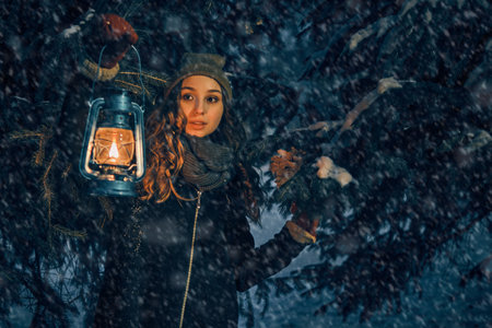 Young girl with lantern in winter forest fairy tale, book coverの写真素材