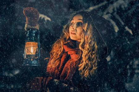 Young girl with lantern in winter forest fairy tale, book coverの写真素材