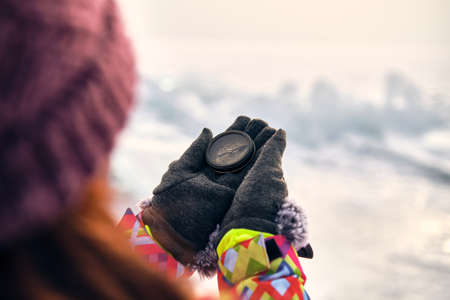 Hiker Hand Holding A Compass And Ices In Backgroundの写真素材