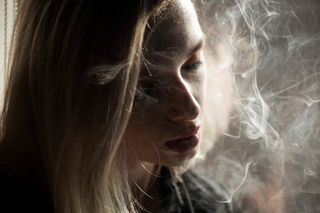 Close-Up Of Young Woman Smoking Cigarette By Window