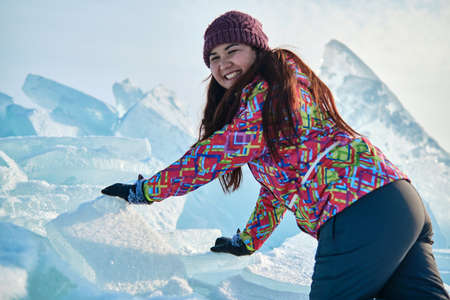 A woman in a ski suit climbs on blocks of ice, fun, fun, rest, winterの写真素材