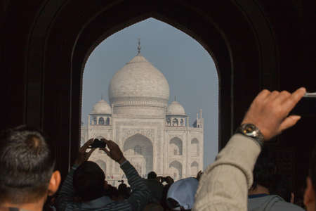 India, Uttar Pradesh, Agra, Taj Mahal, silhouette of tourists with mobile phonesの写真素材