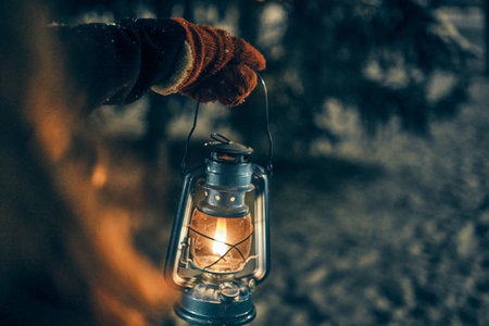 Young girl hand with lantern in winter forest fairy tale, book cover, christmas timeの写真素材