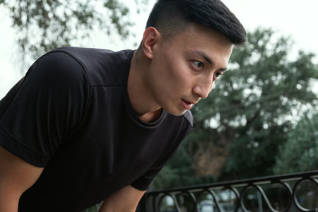 Shot of a handsome young man taking a moment to catch his breath after a morning run in the cityの写真素材