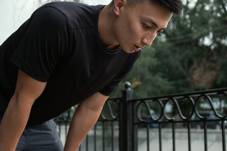 Shot of a handsome young man taking a moment to catch his breath after a morning run in the cityの写真素材