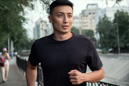 An Asian man running in the city, in the evening. Kazakhstanの写真素材