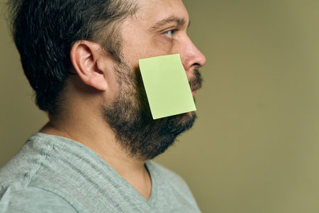 Facial portrait of a man with a beard in profile and covered with blank paper stickersの写真素材