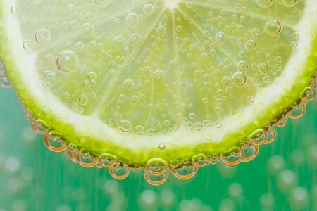 Green lime with water splashの写真素材