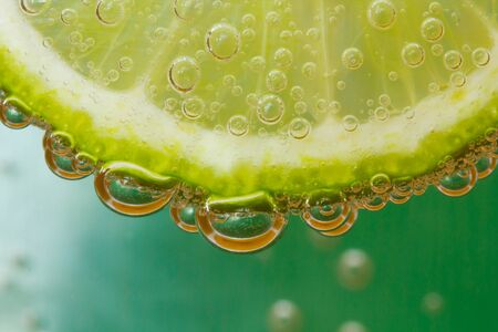 Green lime with water splashの写真素材
