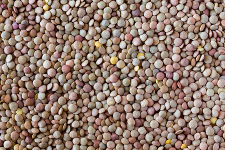 Cooking lentils spilled on the table as a background.の写真素材