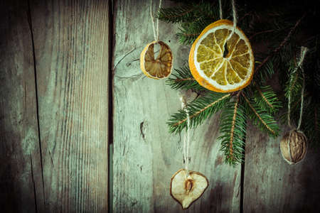 Spruce branches with ornaments on an old wooden board.の写真素材