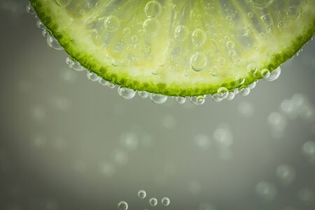 Closeup of the texture of sliced lime in the water with bubblesの写真素材