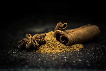 Star anise, cinnamon and ground cinnamon from close range on a black backgroundの写真素材
