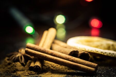 Star anise, cinnamon, coffe, orange and ground cinnamon from close range on a black backgroundの写真素材