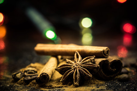 Star anise, cinnamon, coffe and ground cinnamon from close range on a black background