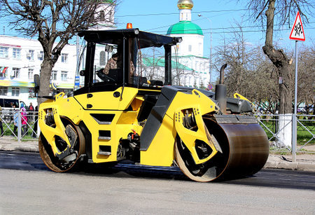 asphalt paver works in the city in the middle of the street