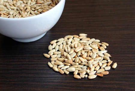 A plate with sunflower seeds peeled on a tableの写真素材