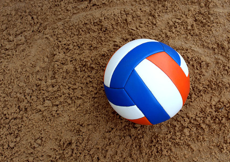 volleyball ball lies on the sand and waits for its playerの写真素材