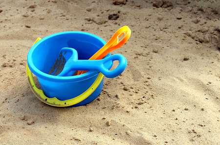 children's shovel and rake and bucket lie on the sandの写真素材