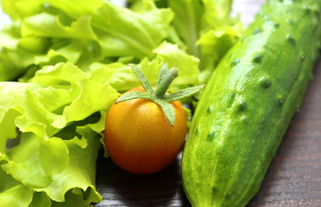 vegetables of a cucumber and tomato salad on the tableの写真素材