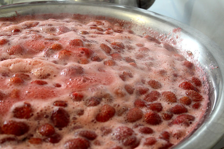 background of strawberry jam boiling with foamの写真素材