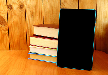 books and a tablet are on the tableの写真素材