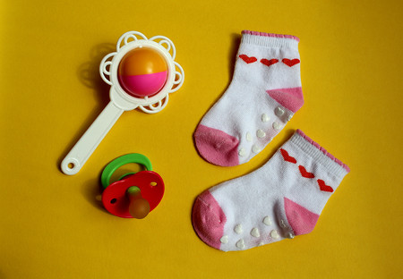 baby clothes socks dummy and rattle backgroundの写真素材