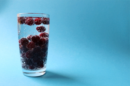cherry in a glass with water with bubblesの写真素材