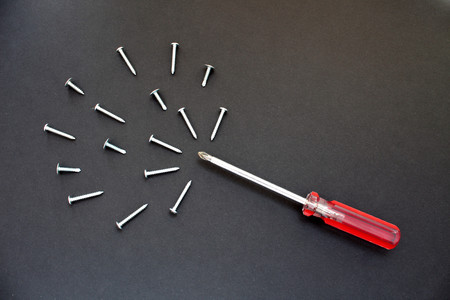 Screws and a screwdriver are on the tableの写真素材