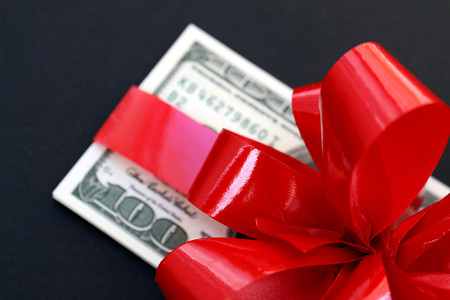 money dollars wrapped in a bow on a giftの写真素材