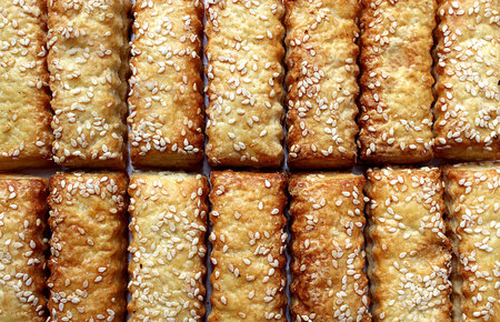 cookies sticks sprinkled with sesame seeds are spread out on the table