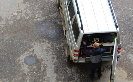 man fumbles in the trunk of a carの写真素材