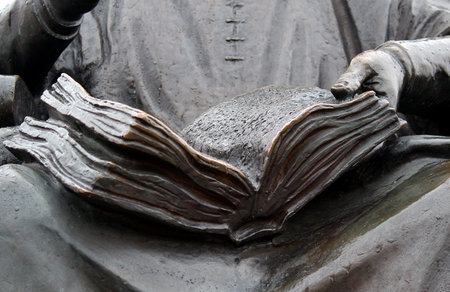 bronze monument man holds an open bookの写真素材