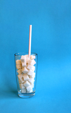 pieces of white sugar are covered in a glass with a tubeの写真素材