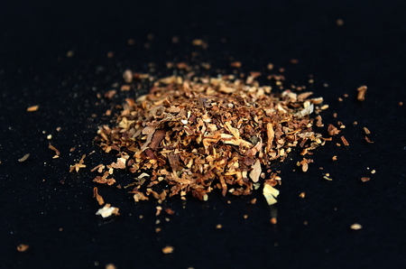 crushed tobacco leaves are in a heap on the tableの写真素材