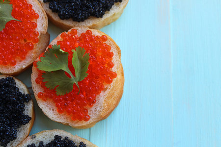 red and black caviar of fish lies on wheat breadの写真素材