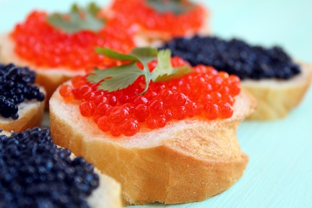 red and black caviar of fish lies on wheat breadの写真素材