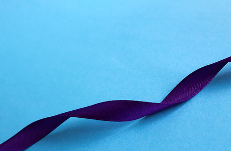 purple satin ribbon wriggles on blue backgroundの写真素材