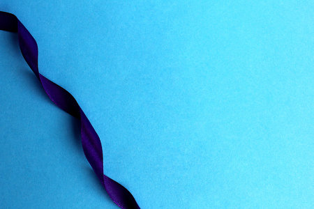 purple satin ribbon wriggles on blue backgroundの写真素材