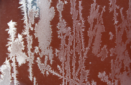 Frozen snowflakes on the glass in cold winterの写真素材