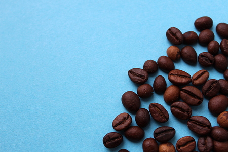 Roasted coffee beans lie on a blue backgroundの写真素材