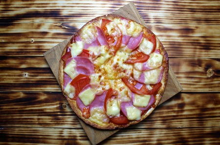 Fresh crispy pizza on a wooden tableの写真素材