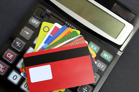 There are several plastic cards on the calculatorの写真素材