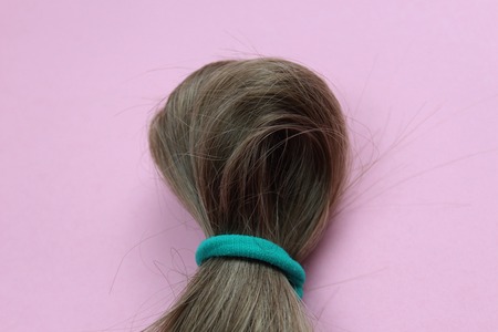 Dark hair folded in half and secured with a rubber bandの写真素材