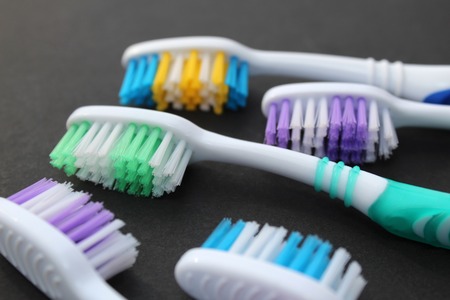 Multi-colored toothbrushes lie on a black backgroundの写真素材