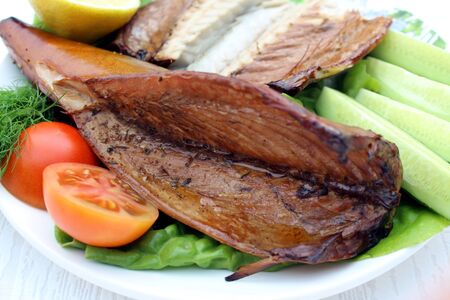 Smoked mackerel on a plate. mackerel with lemon and vegetablesの写真素材