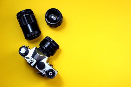 Retro camera. Old film camera with lenses on a yellow backgroundの写真素材