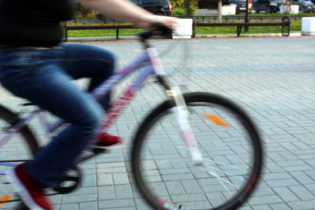 Blurry photo guy rides a bicycle in the evening
