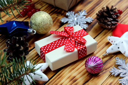 gift box surrounded by christmas items on wooden background