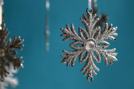 Christmas silver shiny snowflakes hanging on a blue background